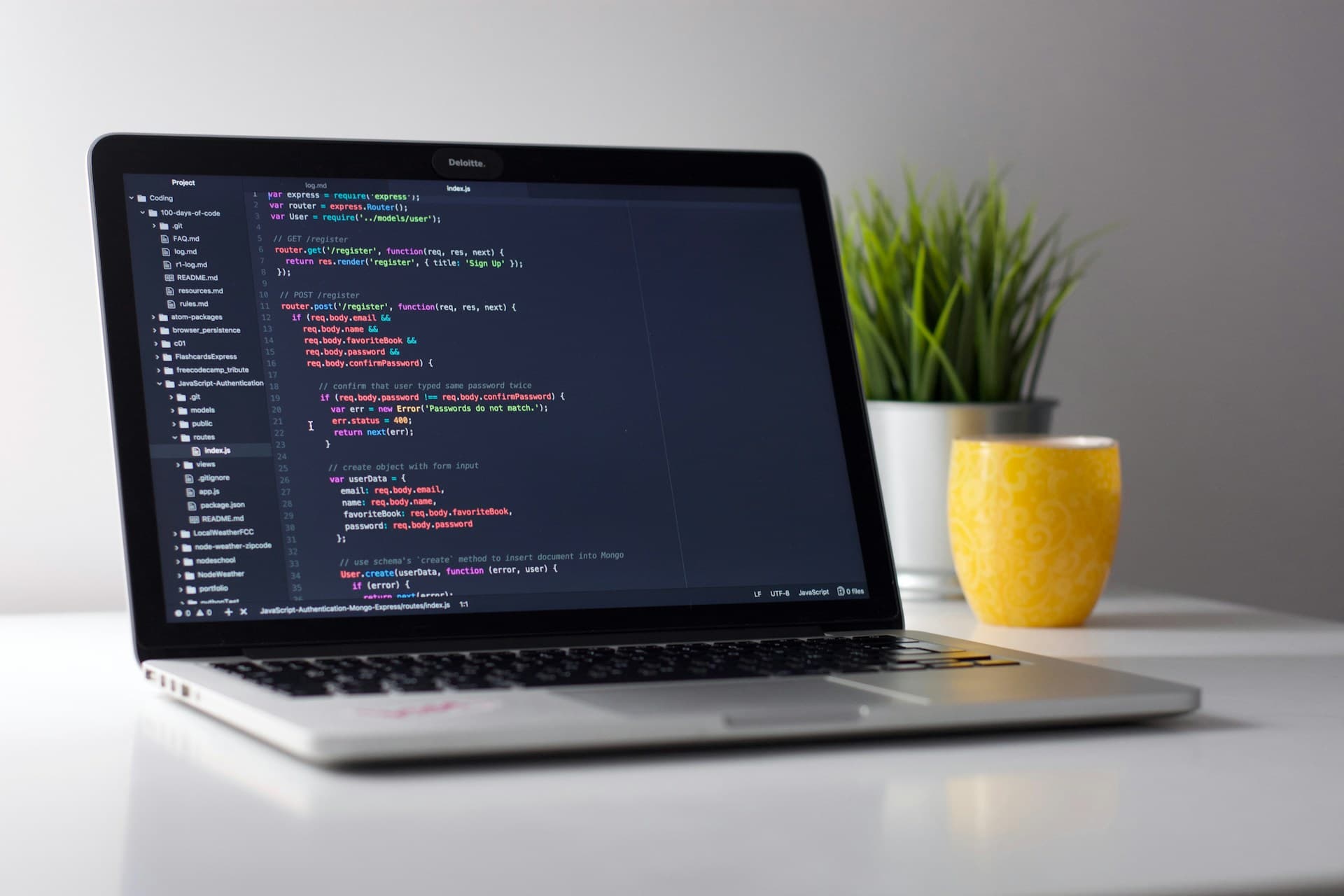Developer workspace with laptop showing application code on display