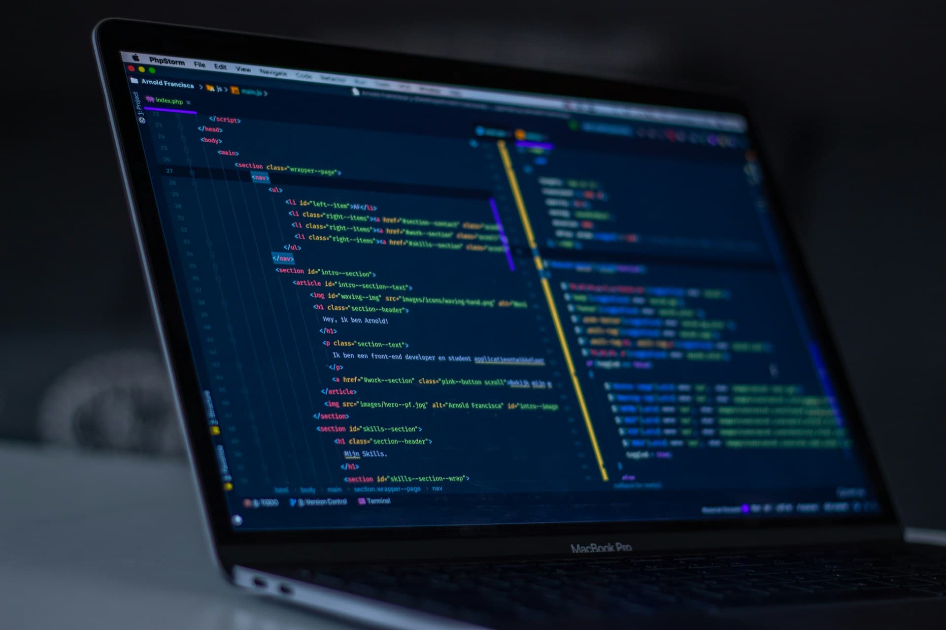 Hands typing on laptop keyboard with coding tutorial on screen
