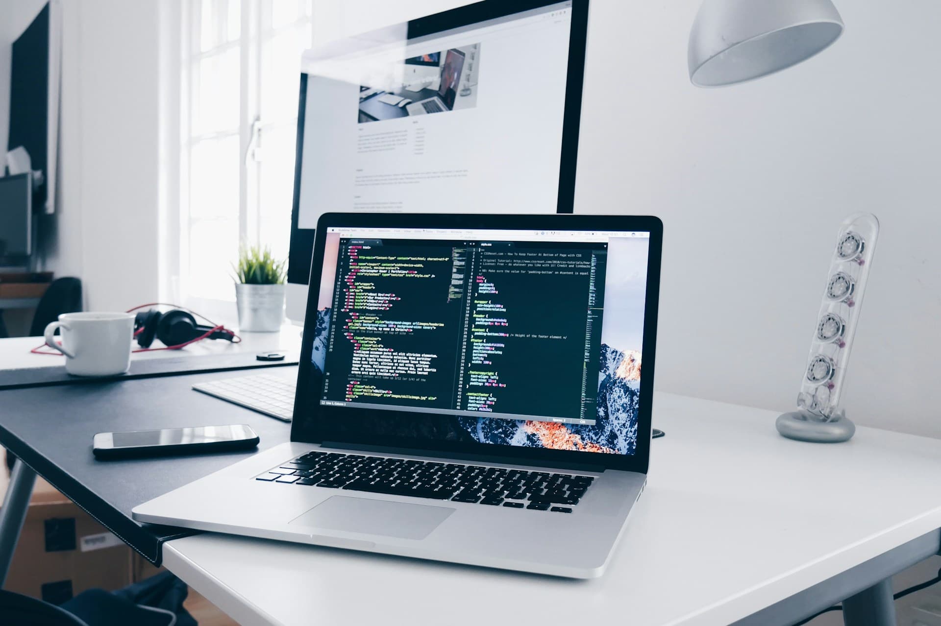Professional laptop on desk with programming environment visible on screen